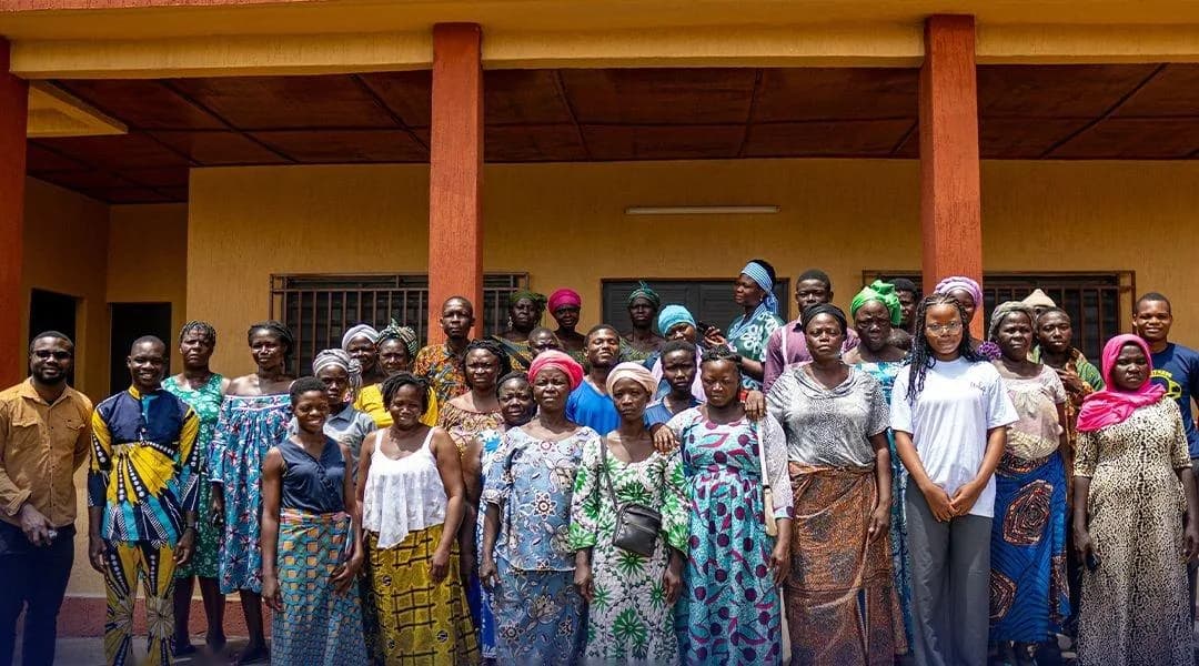 Plusieurs dizaines de femmes réunies devant un bâtiment communautaire pour une session de collecte de données vocales